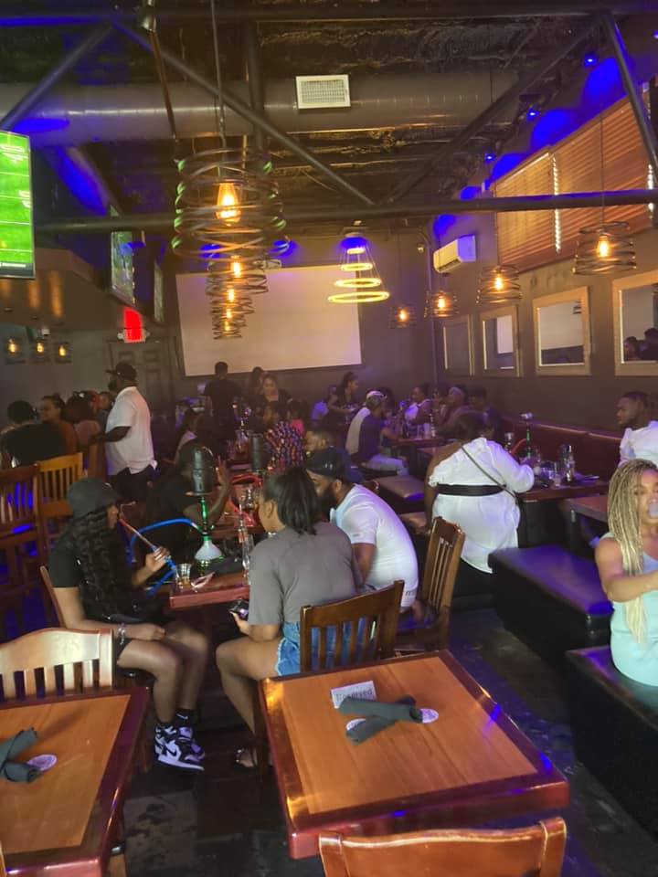 Guests seated at tables in a well lit restaurant at Fin & Feathers