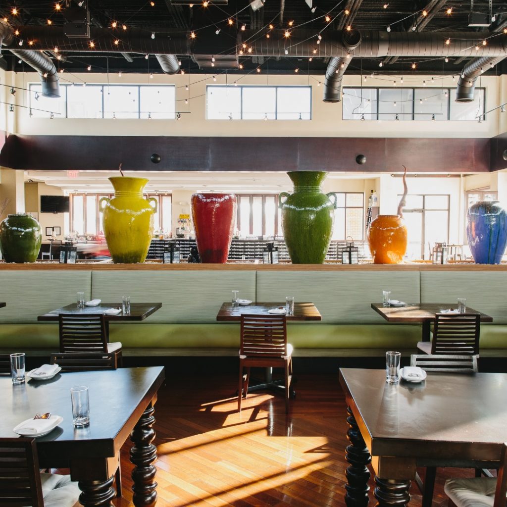 Restaurant festooned with colorful vases, string lights hung overhead and beautifully carved chairs at Tuk Tuk Thai Food Loft