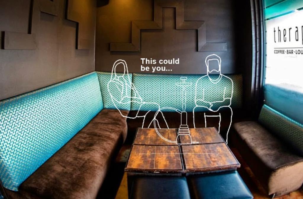 Green and brown sofa set against a brown wall at Therapy Lounge